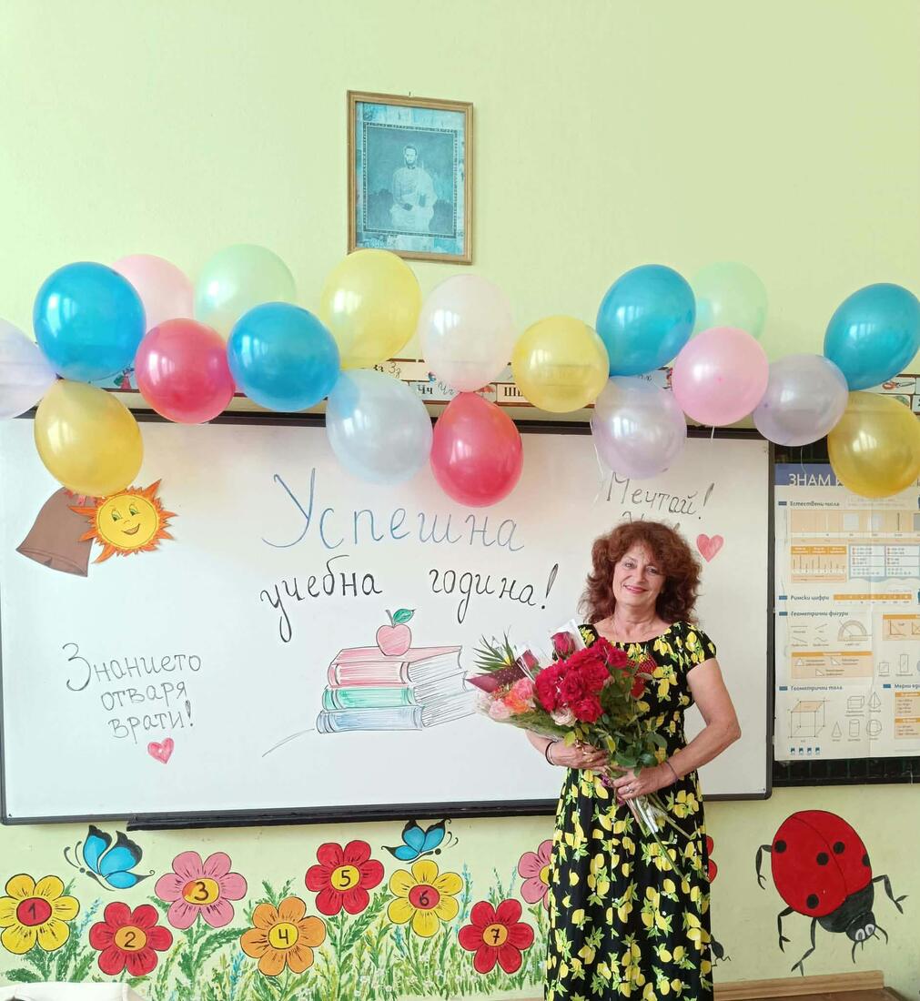 Учителка с букет рози в класната стая с надпис „Успешна учебна година“